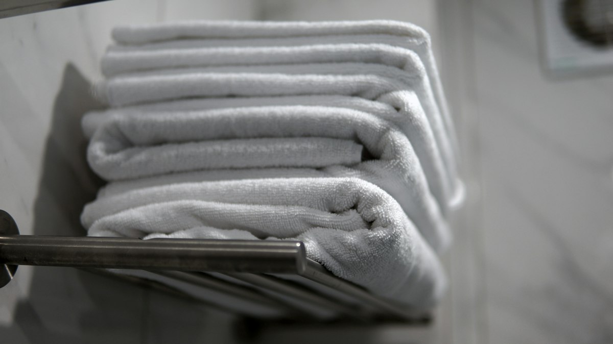 Folded towels on a shelf, illustrating the household laundry task